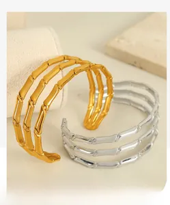 Close-up of gold and silver plated triple-row bamboo joint bangles on stone background