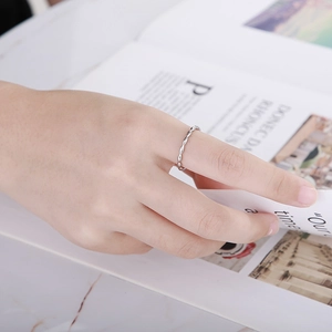 Silver minimalist bead stackable ring worn by model on marble desk background