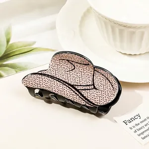 Detail of pink polka dot cowboy hat hair claw clip with stylish ceramic cup props