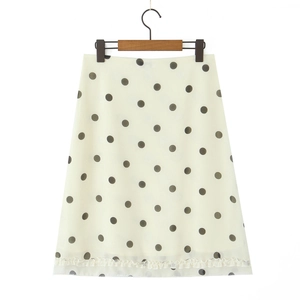 Retro cream A-line polka dot skirt with black spots and ruffle hem on a hanger