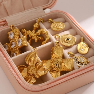 Collectie van 8 gouden titaniumstalen hangers met kruis en hart in een roze sieradendoos