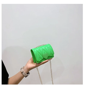 Detail of green silicone heart bag with quilted V-texture and gold chain strap