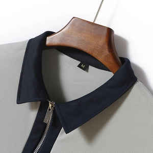Detail of blue collar and zipper on light grey honeycomb knit polo shirt for men