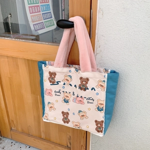 Close-up of canvas tote bag featuring cute bear prints and pink plush handles on the door