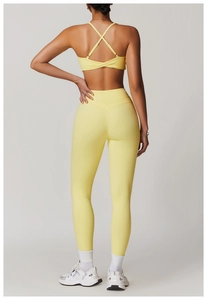 Vista posteriore del set yoga giallo acceso con reggiseno incrociato e leggings a vita alta