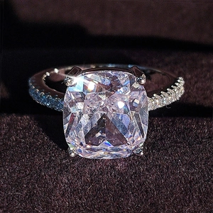 Macro shot of silver ring with large square-cut sparkling center stone and micro-pave setting