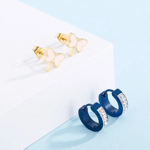 Détails de boucles d'oreilles papillon dorées et créoles en strass bleu marine sur blocs