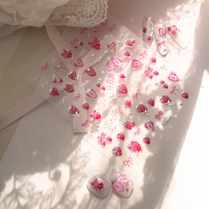 Pink strawberry and bow nail stickers with metallic silver edges on a lace background