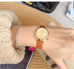 Detailed close-up of a diamond-encrusted gold watch with a grey genuine leather strap