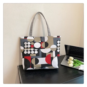 Bauhaus geometric printed canvas tote bag shown on a desk with a laptop and tulips