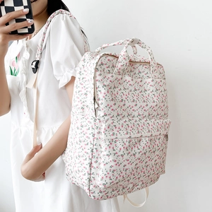 Floral backpack side view showing side profile and front pocket on a model