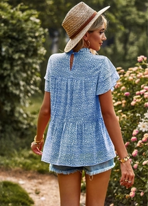 Detail of blue floral print top showing flutter sleeves and back teardrop button closure