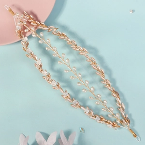Detail of vine-shaped bridal headband with gold metal leaves and delicate pearls