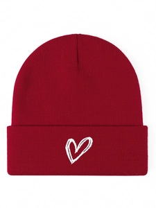 Detail shot of a dark red knit beanie featuring white heart embroidery on a white background