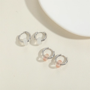 Detailed macro view of minimalist drop earrings with pastel beads and polished silver finish