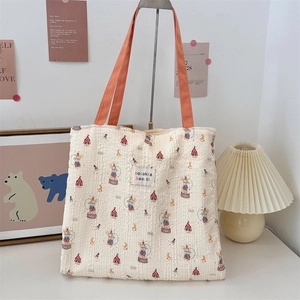 Close-up of the seersucker texture and circus pattern on the cream canvas tote bag