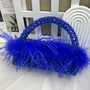 Detail of handcrafted dark blue beaded evening bag featuring ostrich feathers and top handle