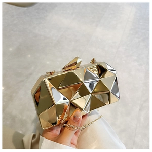 Detail of acrylic evening clutch featuring geometric diamond texture and gold chain strap