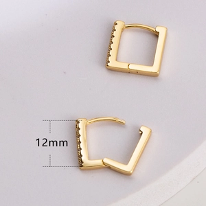 Dettaglio degli orecchini a cerchio quadrati dorati da 12 mm con zirconi