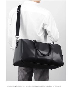 Model showcasing large black lychee pattern leather travel bag with shoulder strap