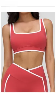 Detail view of raspberry red yoga bra with white contrast trim and square neckline