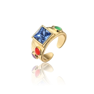 Macro shot of 18K gold ring with large blue square stone and colorful side gems