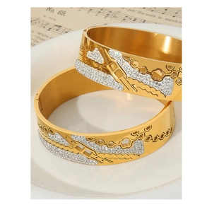 Detail of 18K gold-plated titanium steel bracelets with hollow floral pattern and rhinestones