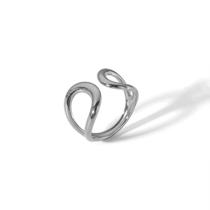 Détail macro d'une bague ouverte argentée minimaliste montrant des lignes géométriques polies