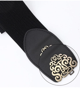 Detail of black elastic waist belt with vintage golden floral carved metal buckle