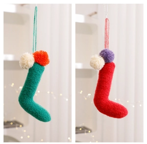 Vista dettagliata di pendenti a forma di calza di Natale in maglia colorata con pompon