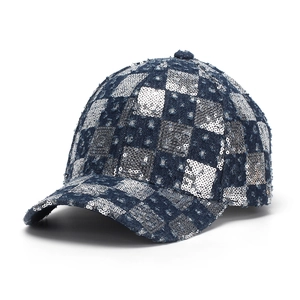 Detail of silver sequins in a checkerboard pattern on dark blue denim baseball cap