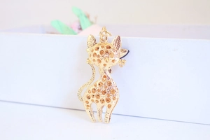 Close-up of a golden hollow cat keychain with textured metal patterns and rhinestones