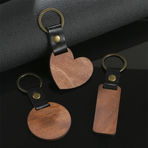 Detail of walnut wood and leather keychains in heart, round and rectangle shapes