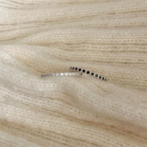 Minimalist 925 sterling silver stacking rings with cubic zirconia on white knit background