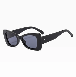 Detail view of black thick-frame cat-eye sunglasses with silver triple-dot metal rivets