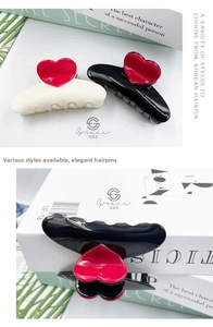 Detail view of cream and black 8.3cm hair claws with glossy red 3D hearts