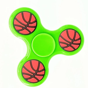 Detail of green three-leaf fidget spinner with basketball pattern weights on white background