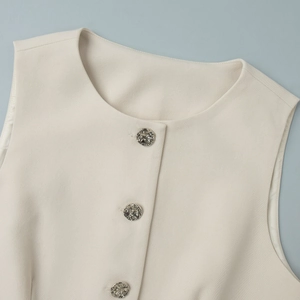 Detailed macro view of beige vest with hammered silver buttons and twill texture fabric
