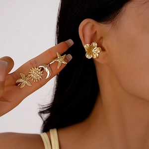 Golden starfish sun and moon non-pierced ear cuffs set with a metallic floral design