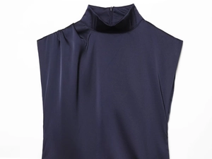 Détail d'un haut sans manches en satin bleu marine avec col montant et plis drapés