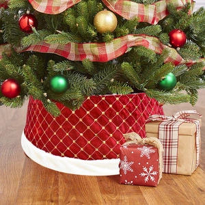 Close-up van een luxe rode fluwelen kerstboomrok met goudborduursel en een witte bontrand