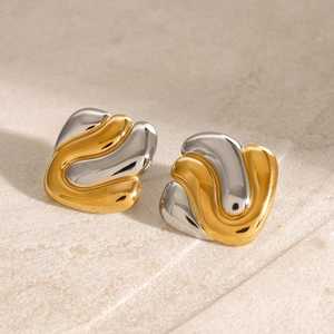 Boucles d'oreilles vagues bicolores en acier inoxydable poli sur fond de pierre
