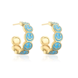 Close-up of 18K gold plated C-shaped earrings with blue enamel smiley faces
