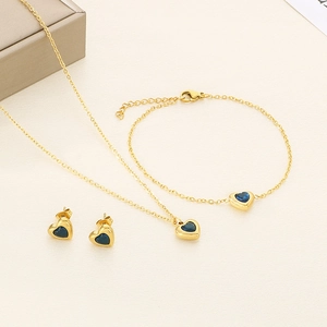 Détail de parure bijoux coeur or 18k avec pierres en verre bleu foncé et boucles d'oreilles