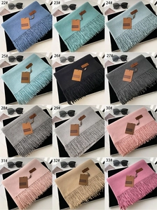 Detailed grid view showcasing twelve colors of fringe scarves with elegant brand tags