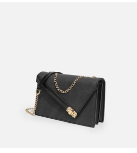 Detail of black cross-grain leather texture and golden metal chain strap on crossbody bag
