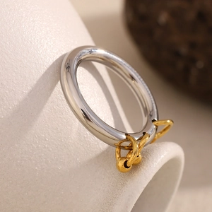Detail of 18K gold plated beaded tassels on a polished two-tone stainless steel ring