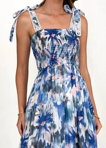 Detailed view of blue floral smocking dress with lace-trimmed ribbon shoulder straps
