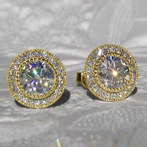 Macro shot of sparkling halo stud earrings with round center stone and milgrain edging