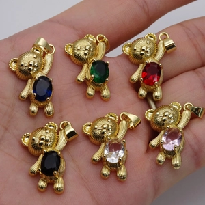 Detailed macro shot of teddy bear pendants with colorful zircons and golden finish